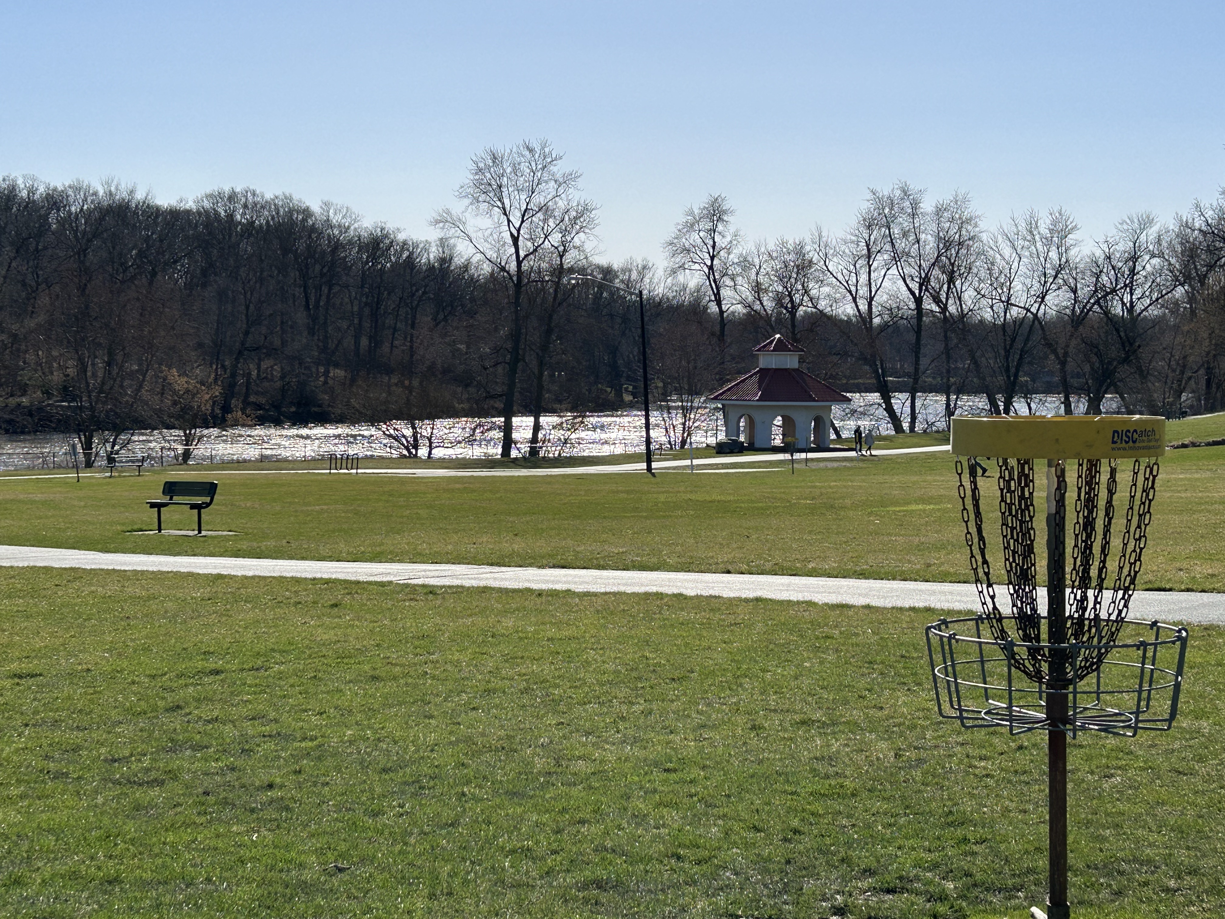 Disc golf basket and distant river at Riverfront Park in Bourbonnais.